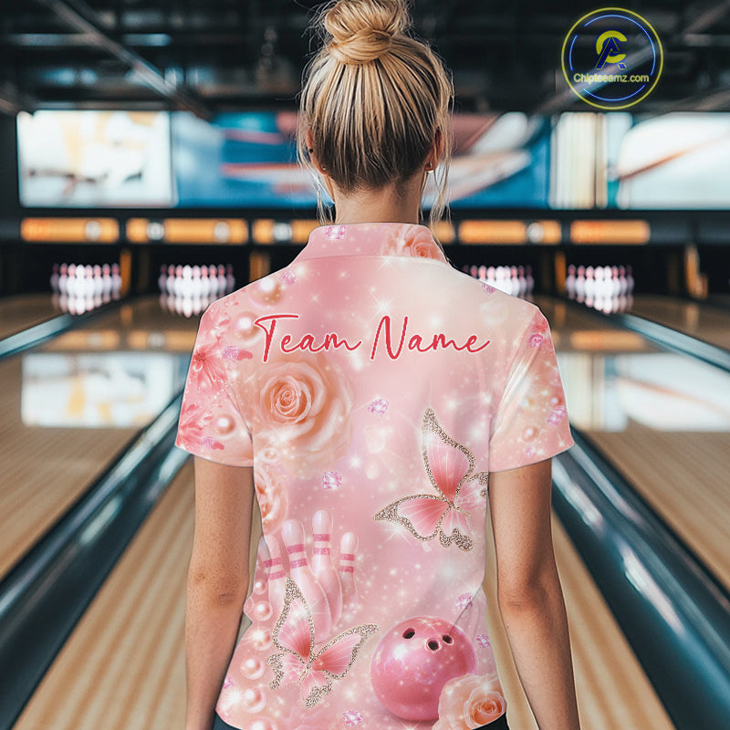 Back view of a female model in a bowling alley wearing a bowling polo shirt showcasing glitter butterfly graphics, diamonds, and bowling artwork.
