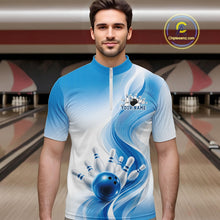 Load image into Gallery viewer, Front view of a male model in a white and blue bowling quarter zip with flowing abstract wave graphics and a glossy bowling ball striking pins