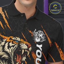 Load image into Gallery viewer, Close-up view of the left chest on a black and yellow bowling polo shirt featuring a roaring tiger holding a yellow bowling ball with orange claw-stripe artwork and a geometric background pattern.
