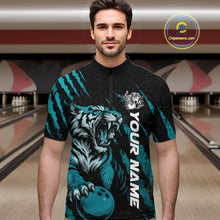 Load image into Gallery viewer, Front view of a male model at a bowling lane wearing a black and teal blue bowling quarter-zip shirt showcasing a roaring tiger holding a teal blue bowling ball with matching claw-stripe graphics and a geometric background pattern.