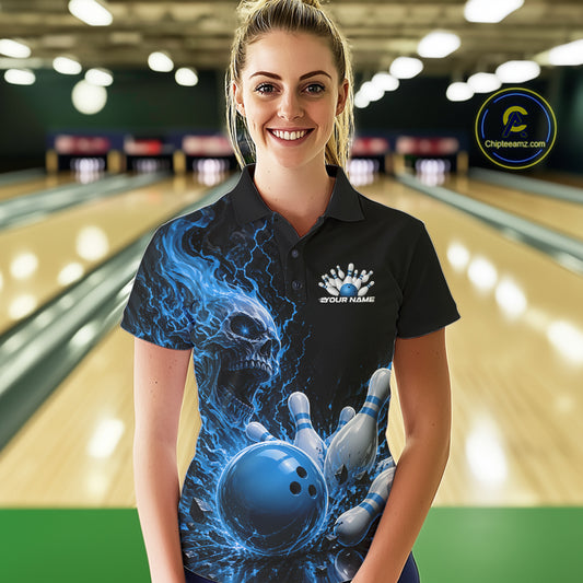 Front view of a female model in a bowling alley wearing a black bowling polo with a blue flaming skull, lightning, bowling pins, and a custom name.
