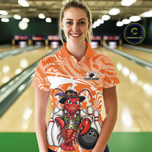 Load image into Gallery viewer, Front view of a female model in a bowling alley wearing an orange custom bowling polo shirt with a funny Cajun crawfish leaning on a bowling ball and a swamp inspired texture background.