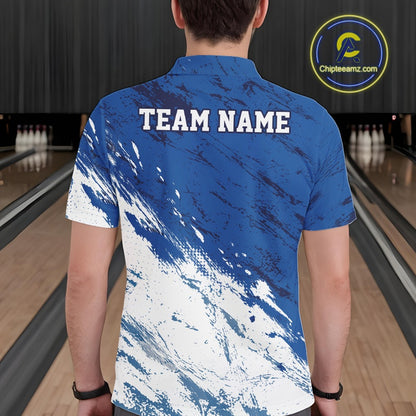 Back view of a male bowler wearing a white and blue bowling polo shirt with a splatter inspired sports jersey pattern in a bowling alley