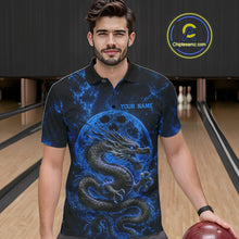 Load image into Gallery viewer, Front view of a male model in a bowling alley wearing a blue custom bowling polo shirt featuring an ancient dragon, flames, and a moon-inspired bowling ball design.