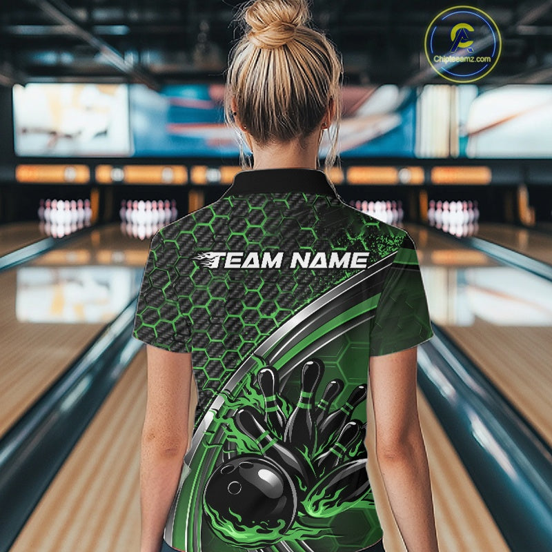 Back view of a female model in a bowling venue wearing a black and green polo shirt, showcasing honeycomb pattern and flame bowling ball hitting pins design.