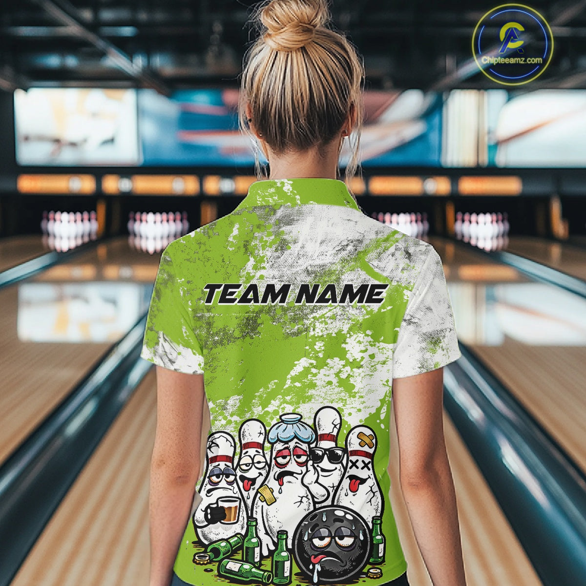 Back view female model in bowling alley wearing white polo shirt featuring green and white grunge splatter, playful drunk bowling pins and beer bottle graphics