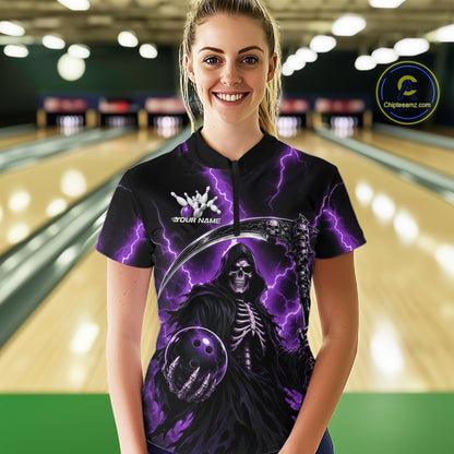 A woman stands in a bowling alley wearing a black short-sleeve polo shirt with a purple lightning and grim reaper graphic. The shirt features a white skeleton logo and the text 'YOUR NAME'.