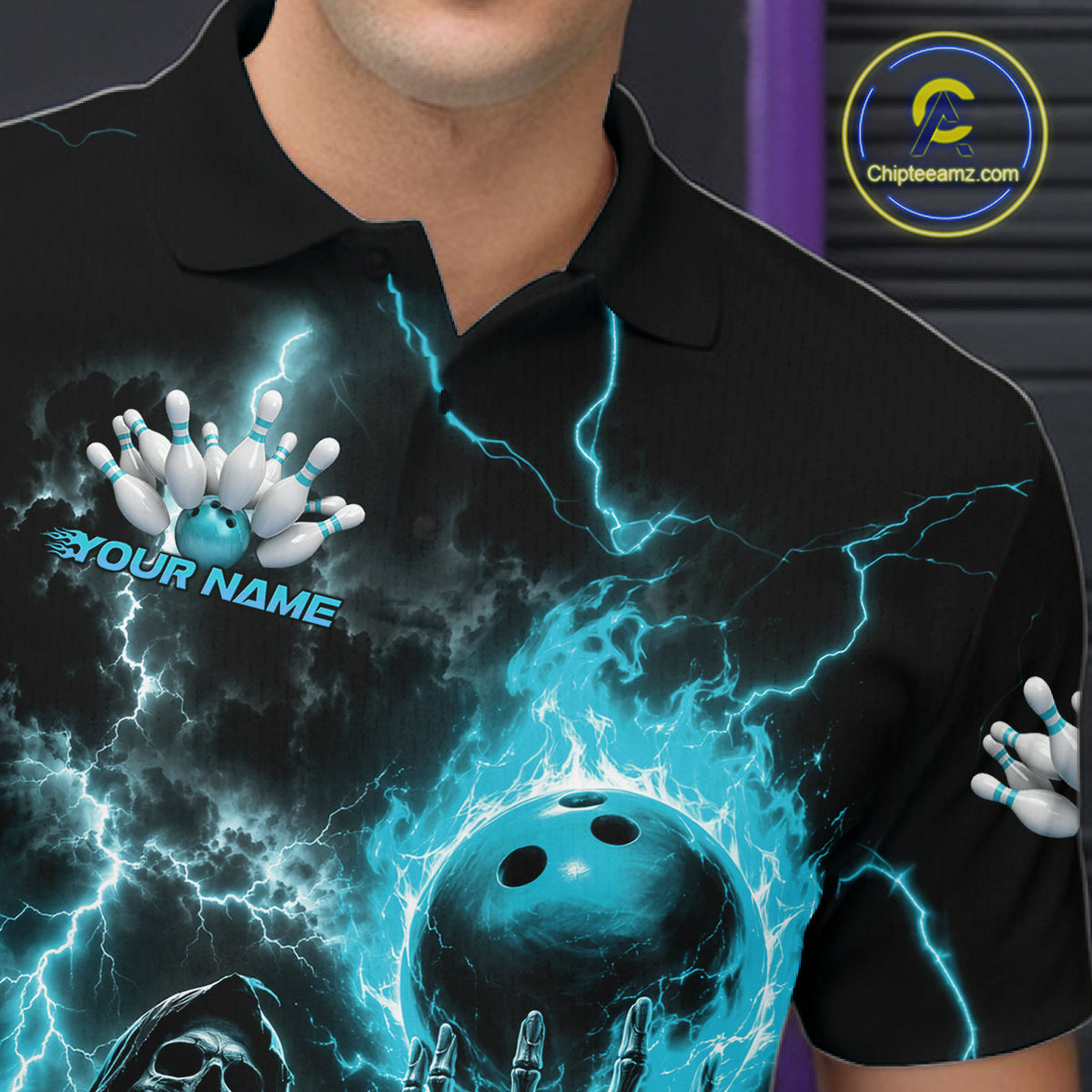 A close-up of a person wearing a black short-sleeve polo shirt with a vivid blue and white bowling-themed graphic print featuring lightning, bowling balls, pins, and a skeleton hand. The shirt has a customizable text placeholder on the chest.