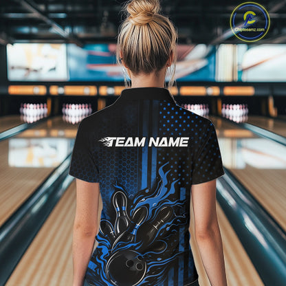 Back view of a female model in a bowling alley wearing a black and blue polo shirt featuring a fiery bowling action scene.