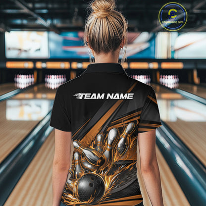 Back view of a female bowler wearing a black quarter-zip shirt, gold flame bowling strike artwork with geometric stripe accents.