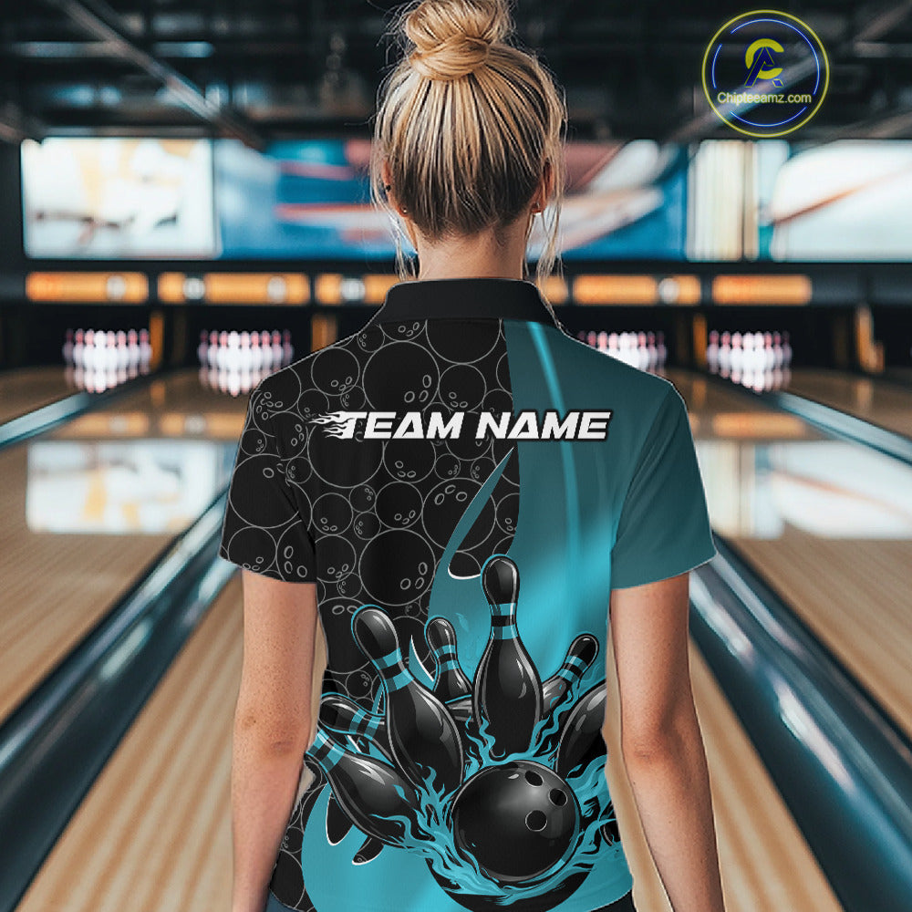 Back view of a female model in a bowling lane wearing a black and blue polo shirt featuring flaming black bowling ball striking pins with bold sports styling.