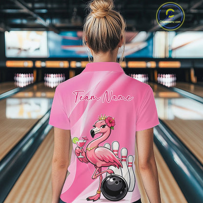 Back view of a female model in a bowling center wearing a pink quarter-zip shirt featuring flamingo-themed bowling artwork and hibiscus flowers.