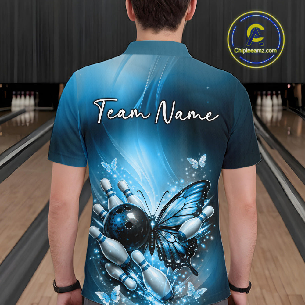 Back view of a male model in a bowling alley wearing a blue polo shirt featuring a butterfly beside a bowling ball and bowling pins.