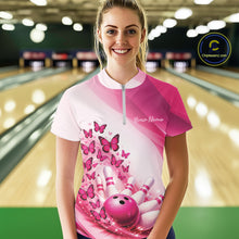 Load image into Gallery viewer, Female model wearing a white and pink bowling quarter zip with butterfly artwork and bowling graphics, front view inside a bowling alley