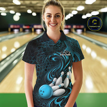 Load image into Gallery viewer, Female model standing in a bowling lane wearing a black and blue bowling polo shirt featuring a tribal flame bowling ball and pins graphic on the front.