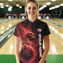 Load image into Gallery viewer, Front view of a female bowler in a bowling lane wearing a black bowling quarter-zip shirt with a swirling red flame skull gripping a bowling ball