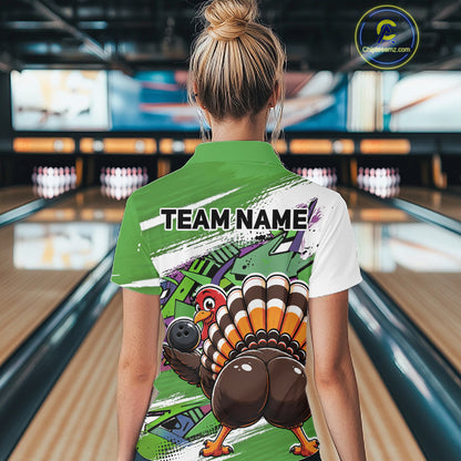 Back view of a female model wearing a green custom bowling polo shirt with a funny graffiti turkey holding a bowling ball, paint splatter accents, and a personalized name in a bowling alley.