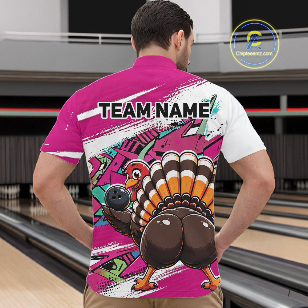 Back view of a male model in a bowling alley wearing a pink custom quarter zip bowling shirt with a funny graffiti turkey holding a bowling ball, paint splatter accents, and a personalized name.