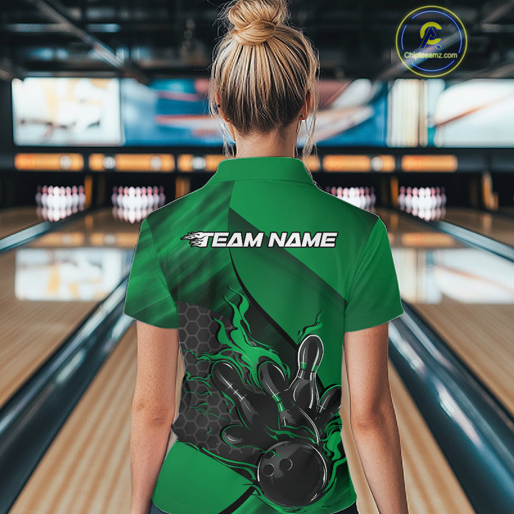 Female model at a bowling lane, back view of black and green quarter zip shirt showcasing flame bowling ball hitting pins with geometric hexagon pattern