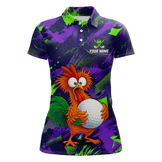 A women's short-sleeve polo shirt with a purple and green paint-splatter background, featuring a cartoon orange rooster holding a white golf ball on the front. The shirt has a white collar, three-button placket, and a white text placeholder reading 'YOUR NAME' with a golf club and ball logo on the left chest.