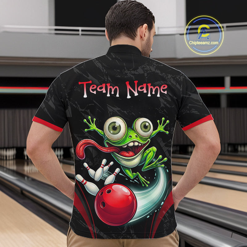 A man viewed from behind wearing a black bowling-themed short-sleeve shirt with a large green cartoon frog, red bowling ball, and 'Team Name' text on the back, standing in a bowling alley.