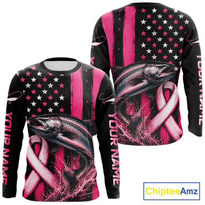 Front and back views of a long-sleeve custom fishing t-shirt on a white background. The shirt features a black and pink American flag design with white stars, a large pink and black rainbow trout graphic, and customizable text 'YOUR NAME' printed vertically on the sleeves.