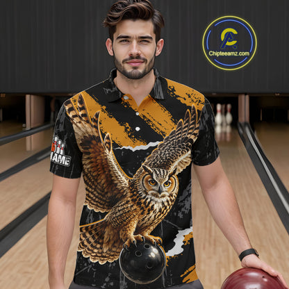 A man in a bowling alley wearing a short-sleeve button-up shirt with a large owl graphic on the front. The shirt has a black and gold pattern with a detailed brown owl and a bowling ball graphic.