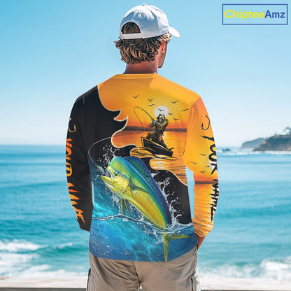 Person wearing a mahi mahi long sleeve fishing shirt with a fishing design by the ocean.