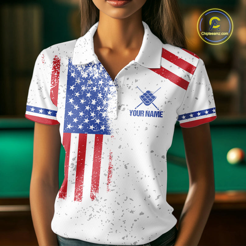 Woman wearing a white American flag 9 ball billiard jersey beside a pool table front view.