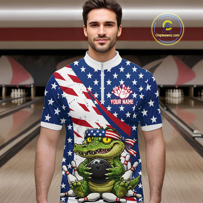 Man wearing a bowling shirt with American flag design and a green alligator holding a bowling ball in a bowling alley.