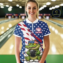 Load image into Gallery viewer, Person wearing a bowling shirt with an alligator holding a bowling ball design and American flag, in a bowling alley.