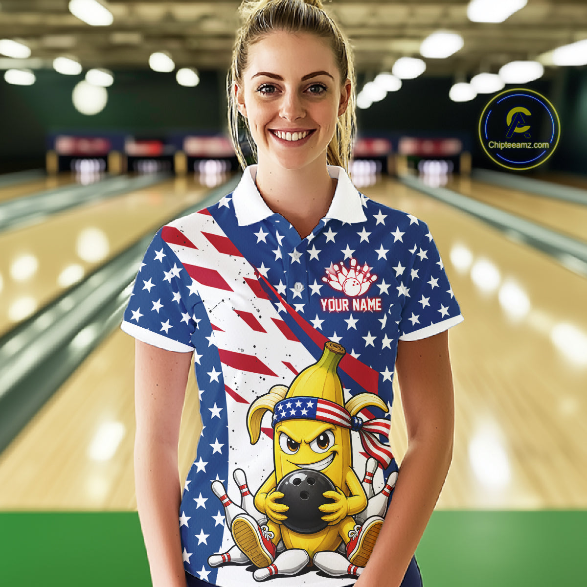 Woman wearing a patriotic-themed polo shirt with a banana cartoon character holding a bowling ball in a bowling alley.