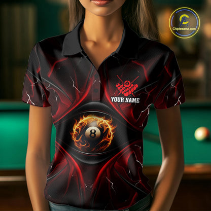 Woman wearing a black and red flame 8 ball billiard jersey beside a pool table front view.