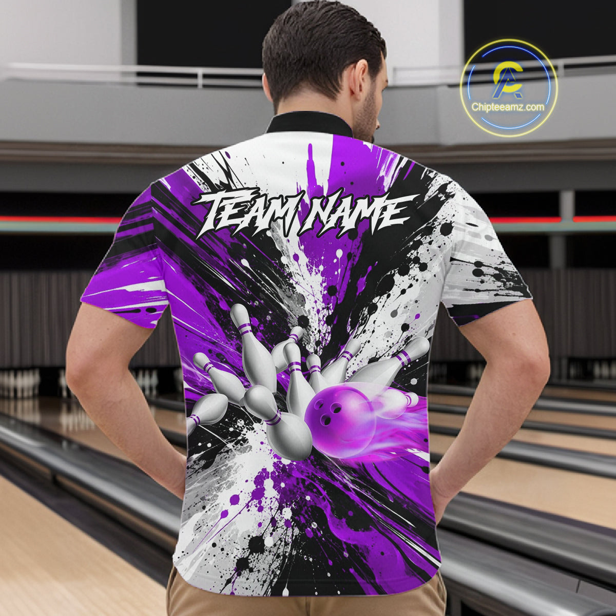 Back view of man wearing a purple splatter bowling quarter zip shirt in a bowling alley.