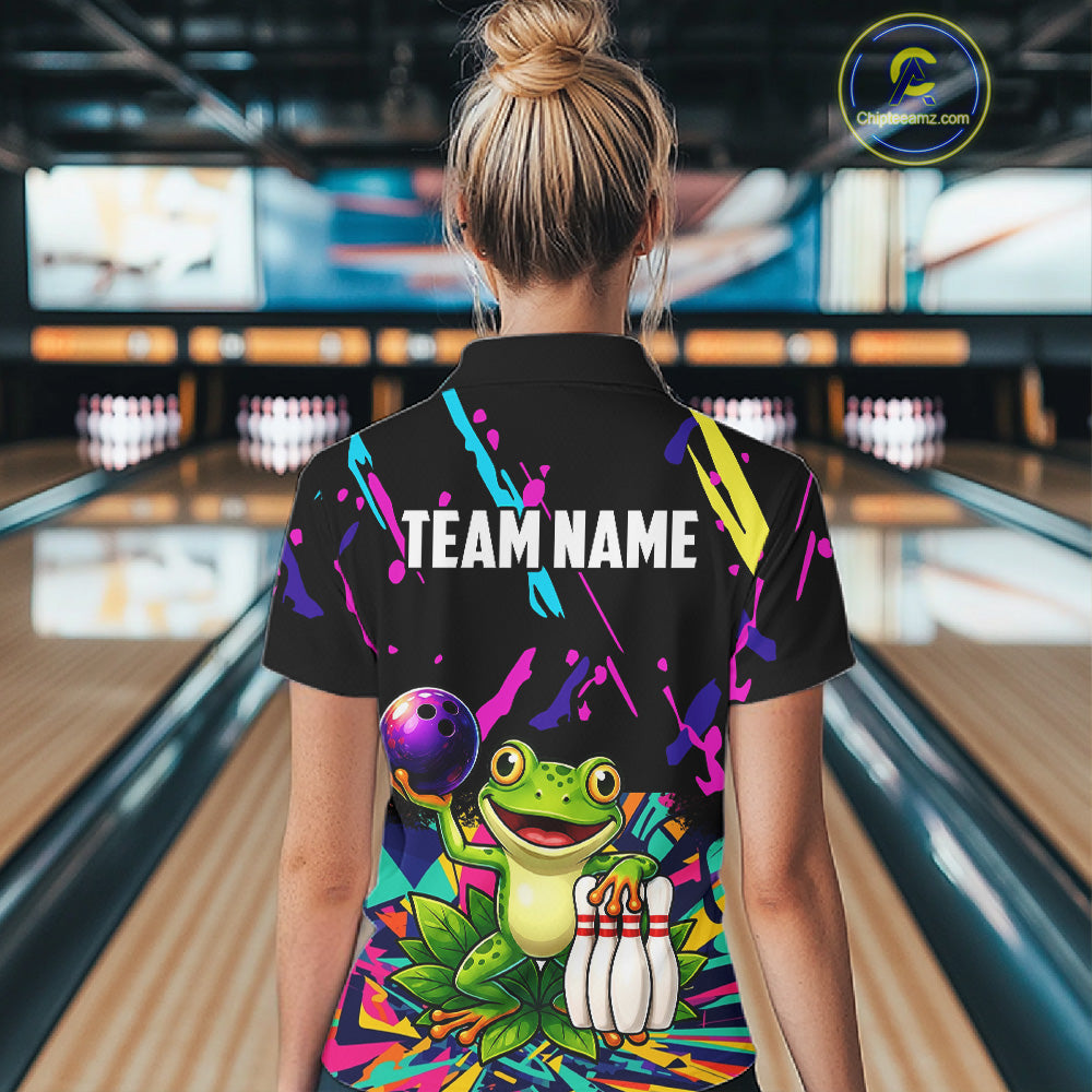 Person wearing a colorful bowling-themed shirt with a frog design in a bowling alley.