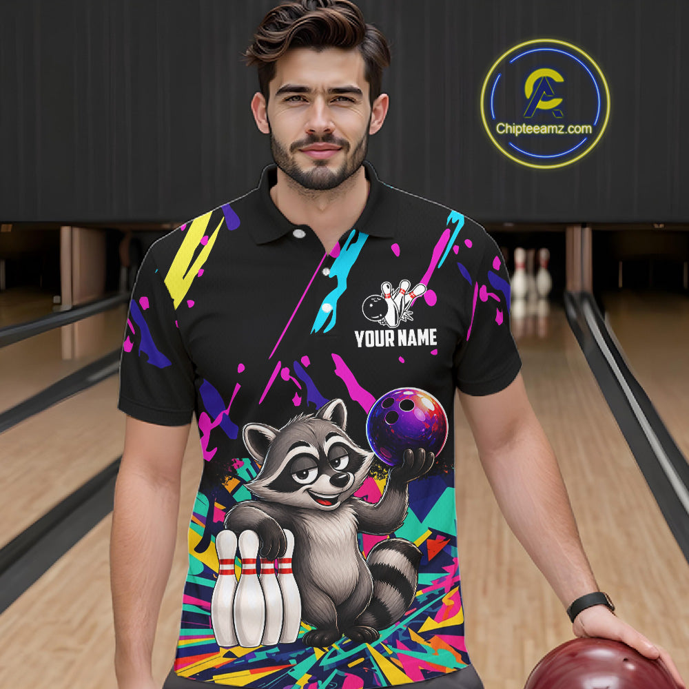 Man wearing a colorful bowling-themed shirt with a raccoon graphic in a bowling alley.