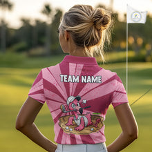 Load image into Gallery viewer, Female golfer wearing custom pink flamingo golf polo during a sunny golf tournament, breathable performance golf apparel for women golfers, tropical vacation lovers, flamingo enthusiasts and resort lifestyle fans. Symbolizes confidence, elegance, freedom and joyful living.
